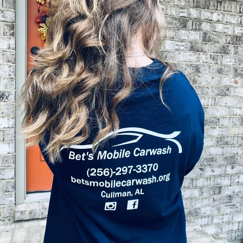 The back of a BMC crew shirt printed with the logo, 256-297-3370, betsmobilecarwash.org and Cullman, AL